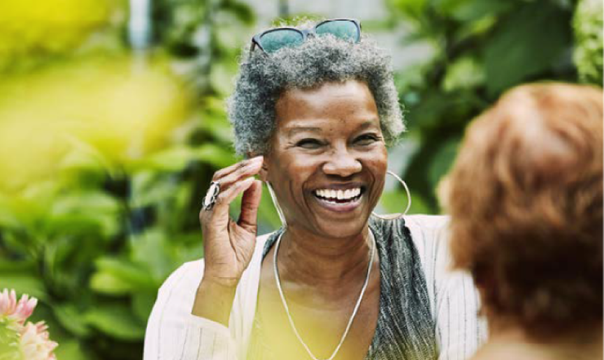 A retirement communities resident laughing in a garden