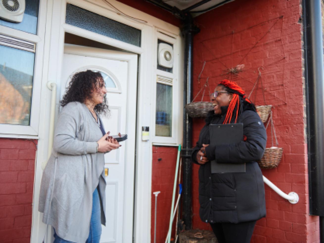 Sanctuary resident talking to a housing officer outside of her front door